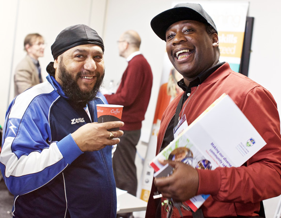 Two-men-attending-a-VAL-funding-fair-and-smiling-at-the-camera